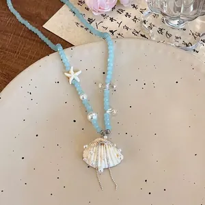 Détail du collier de perles avec étoile de mer, pendentif coquillage et perles