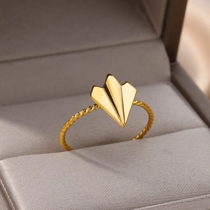 Macro shot of 18k gold plated stainless steel ring with paper plane and twisted band