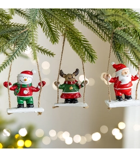 Detailed view of Santa, snowman, and elk resin ornaments hanging on a Christmas tree