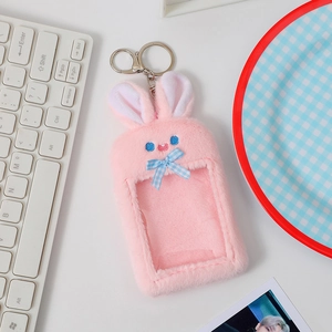 Detail of pink plush rabbit card holder featuring a blue plaid bow and clear back window