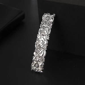 Close-up of vintage rectangular hair clip with embossed floral sunflower patterns