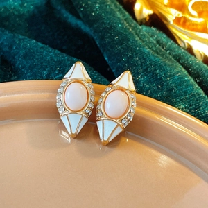 Gros plan sur les boucles d'oreilles vintage avec pierre rose et cristaux sur velours
