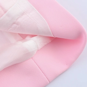 Macro shot of pink blazer fabric showing soft texture and white textured lining