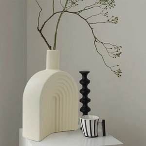 Modern minimalist cream ceramic arch vase with wavy texture and green plant branch decor