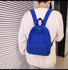 Nahaufnahme des blauen Segeltuch-Rucksacks am Model, zeigt Reißverschluss und Textur