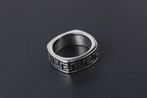 Macro shot of silver men's titanium ring featuring square edge and Greek key pattern