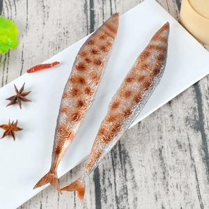 Realistic roasted saury fish prop in a white plate on a wooden table with spices