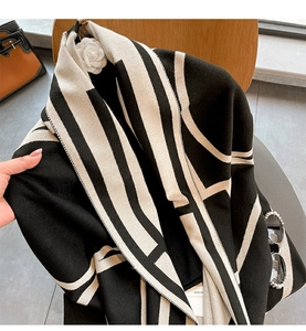 Close-up of thick geometric stripe knit shawl with OM letter pattern and soft texture
