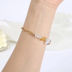 Gold stainless steel bracelet featuring natural crystal stones worn on a female wrist