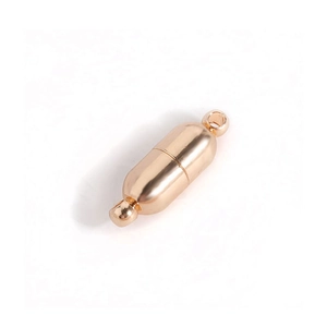 Detailed macro view of a gold-plated cylindrical heart magnetic clasp jewelry connector