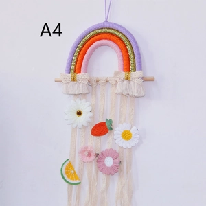 Detail of woven rainbow wall hanging with lace ribbons for hair clip storage