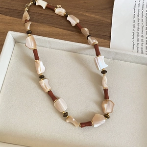 Macro shot of stone and mother of pearl beaded necklace with vintage gold lobster clasp