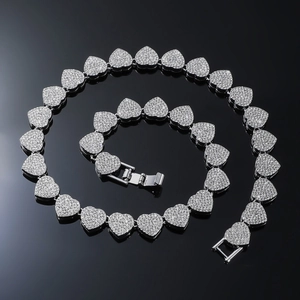 Close-up of heart-shaped cuban links paved with clear crystals on a silver necklace