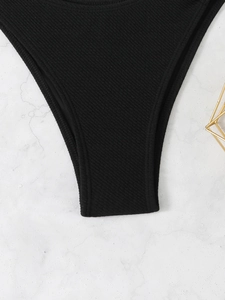 Vista macro della trama a coste dello slip bikini nero su superficie di marmo