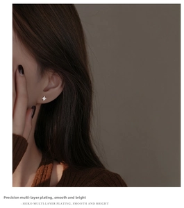 Macro shot of S925 sterling silver star earring with zircon on a model's ear