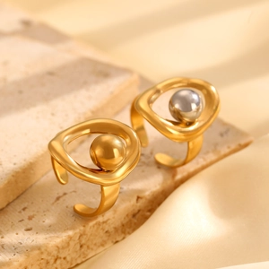 Macro shot of abstract geometric open rings with gold and silver bead details on stone