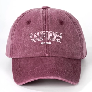 Detailed close-up of washed burgundy cotton baseball cap with white California print