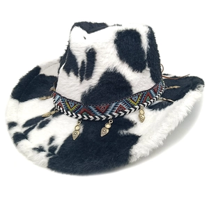 Close-up of cow print cowboy hat featuring ethnic braided band and gold leaf charms