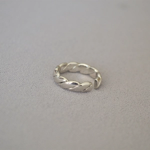 Detailaufnahme eines minimalistischen silbernen verstellbaren Rings mit Webstruktur