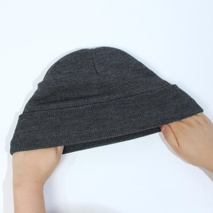 Detail shot showing the high elasticity and stretchy knit fabric of the dark grey beanie