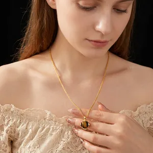 Vintage gold tiger eye stone clover pendant necklace worn by model on white top