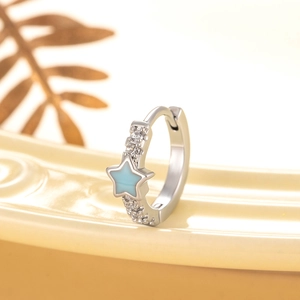 Silver star earrings with light blue enamel and sparkling crystals on a ceramic tray