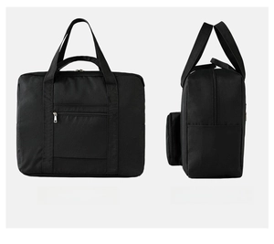 Detail of black oxford travel bag showing the luggage handle strap and side pocket