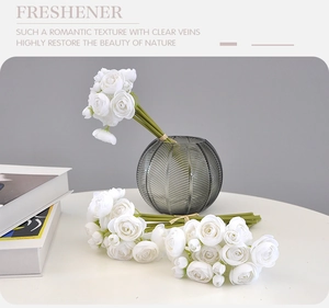 Detailed close-up of white silk ranunculus flowers in a frosted vase for home decor