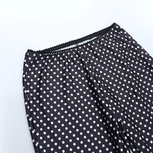 Gros plan du pantalon à pois avec taille élastique et bords ondulés pour un look moderne