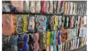 Assorted satin and plush eye masks with various prints and colors on display