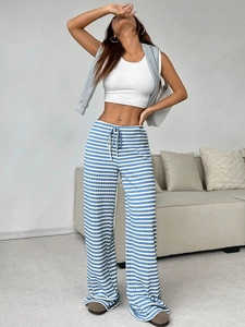 Detail of blue and white striped knit straight-leg trousers with drawstring waist