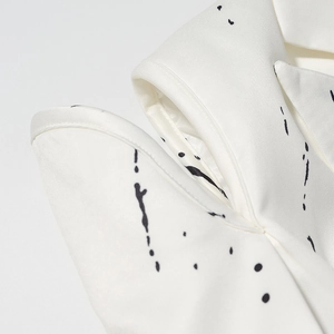 Close-up of white blazer with black abstract ink print and fine twill fabric texture
