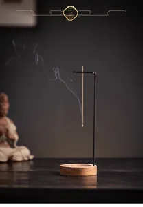 Minimalist wooden incense holder with metal bracket showing rising smoke in zen style