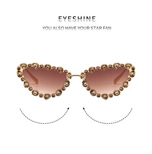 Detail view of cat eye sunglasses with gold frame and sparkling brown gradient crystals