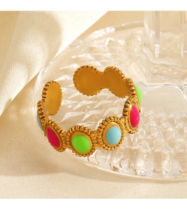 Detailed view of gold beaded open ring with pink, green, and blue oval enamel accents