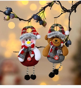 Detail of Christmas snowman and brown bear plush ornaments with knitted scarves