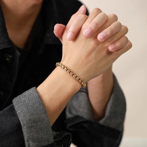 Close-up of men's gold stainless steel square box chain bracelet on a wrist