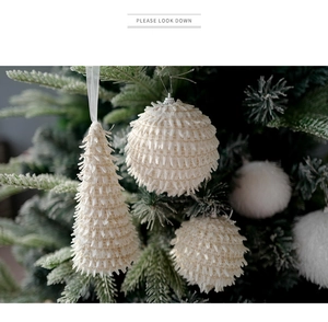 Macro shot of cream Christmas tree ornaments with soft fringe and flocked texture