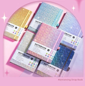 Flat lay of colorful glitter A5 hardcover notebooks with elastic straps and dotted pages