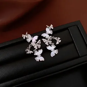 Boucles d'oreilles papillon en nacre avec glands de zircone sur soie foncée