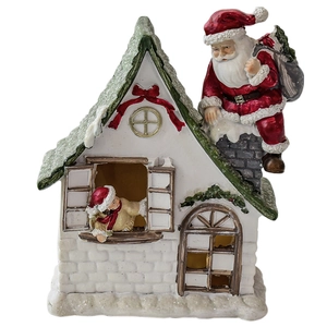 Miniature resin Christmas house with Santa climbing chimney for festive tabletop decor