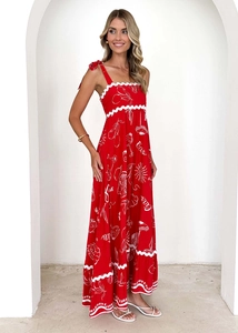 Detail of red floral spaghetti strap dress with white wavy trim and Ciao print