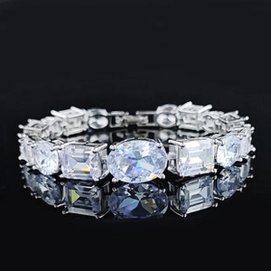 Macro shot of sparkling oval and radiant cut stones on luxury silver chain with mirror reflection