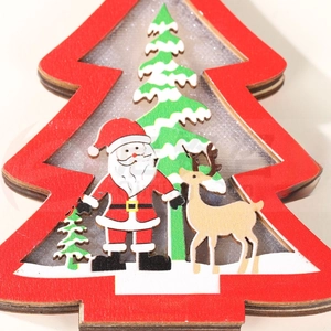 Close-up of a red wooden Christmas tree ornament with painted Santa and reindeer scenes