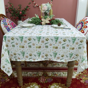Waterproof Christmas tablecloth with green trees and gifts on a wooden table setting