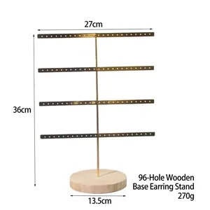 Detail of a 4-tier golden metal jewelry stand with 96 holes and a round wooden base