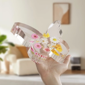 Detailed view of a butterfly bookstand mold with real dried flowers and gold leaf foil
