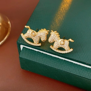 Exquisite gold-plated horse earrings with sparkling diamonds on a green luxury gift box
