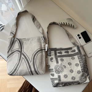 Detail of cotton linen tote bags with paisley and abstract prints on a wooden desk