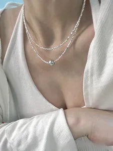 Close-up detail of double-layer S925 silver necklace with minimalist pearl pendant